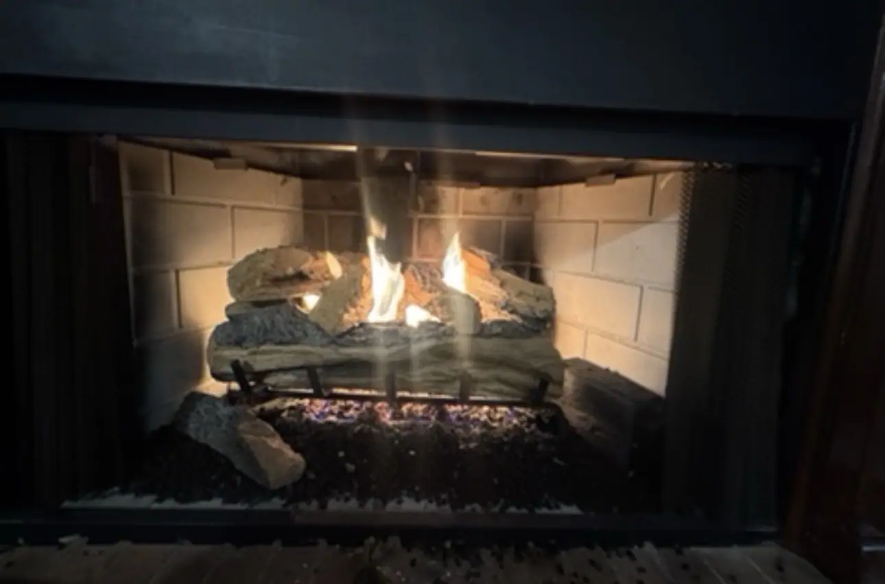 Original PüR-AyR gas fireplace job photograph with lit logs